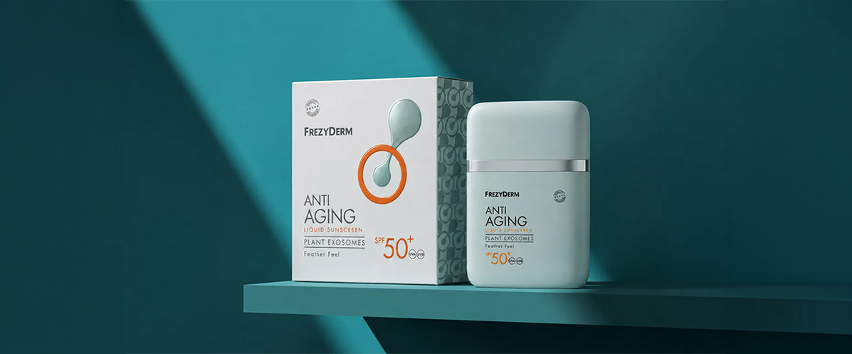 Minimalist packaging and bottle of Frezyderm Anti Aging Liquid Sunscreen SPF 50+ against a teal background.