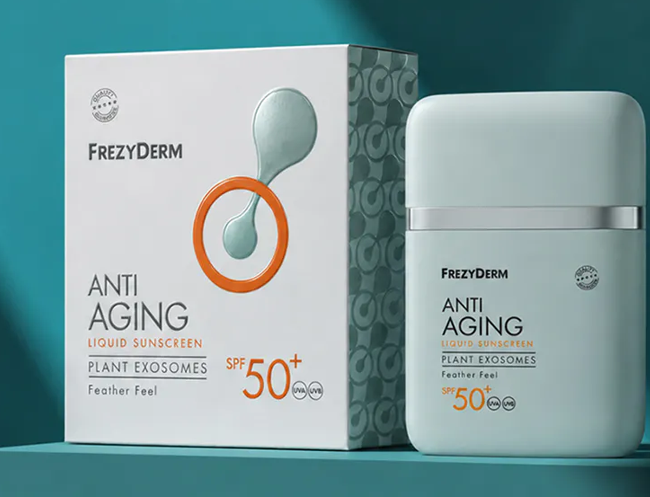 Minimalist packaging and bottle of Frezyderm Anti Aging Liquid Sunscreen SPF 50+ against a teal background.